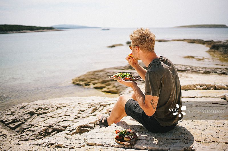 年轻男人吃新鲜三明治图片素材