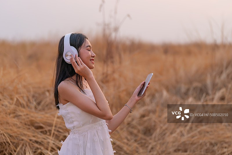 自然旋律：年轻亚洲女人拥抱宁静与歌声图片素材