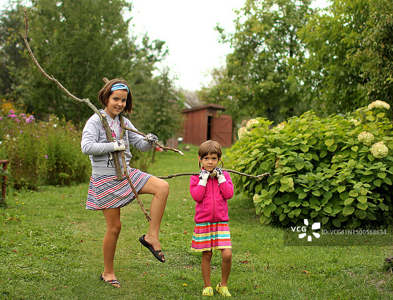 两个可爱的小女孩在乡下帮忙园艺图片素材