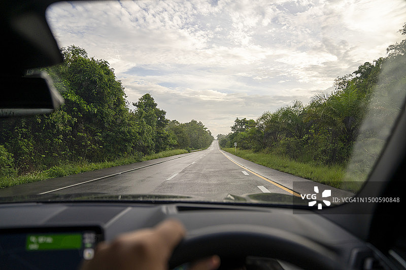 汽车司机握着方向盘，在高速公路上自驾图片素材