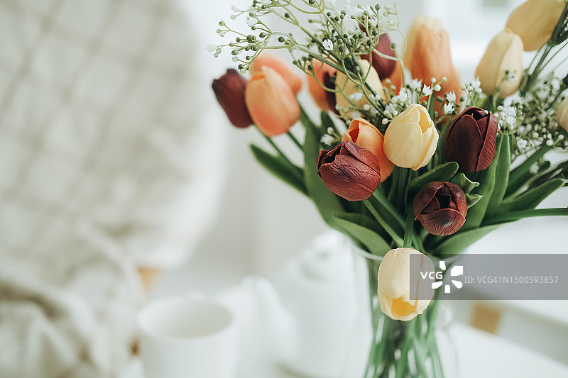 花瓶中的彩色郁金香和白色花朵图片素材