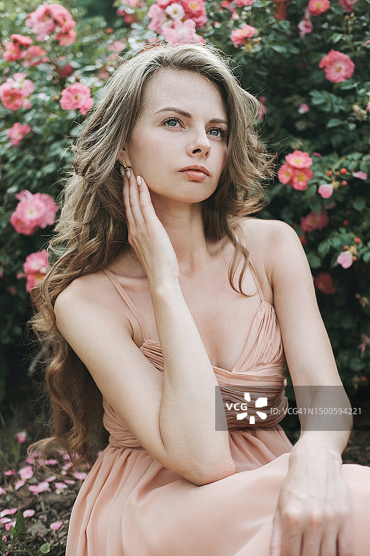 年轻女人与弗里德里克女公爵玫瑰灌木合影图片素材