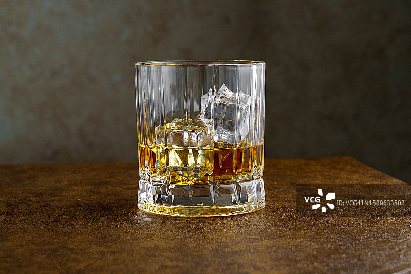 深色桌子上加冰的威士忌酒图片素材