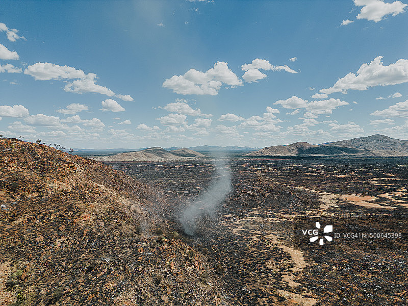 从空中拍摄的在山边的尘卷风，澳大利亚北部地区的塔纳米沙漠图片素材