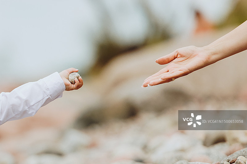 一只小手递给成年人石头的手部局部照片图片素材