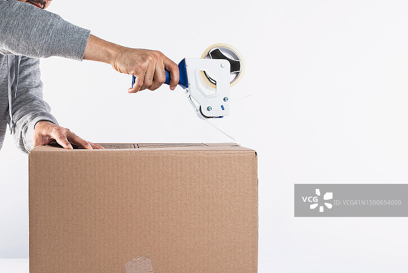 男人在白色背景前打包纸箱，印度尼西亚图片素材