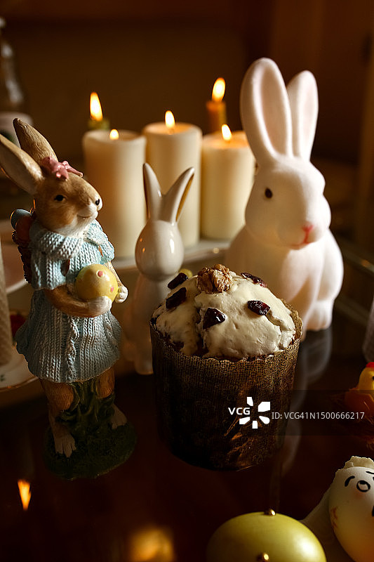 特写：俄罗斯桌上蜡烛和鲜花旁的复活节兔子图片素材