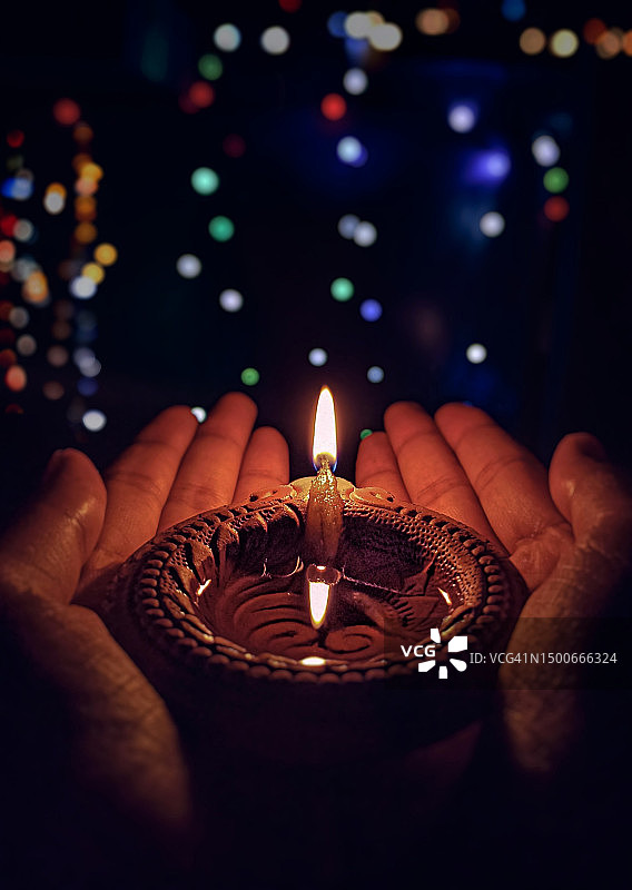 在印度恰蒂斯加尔邦赖布尔专区，夜晚手持蜡烛的局部特写图片素材