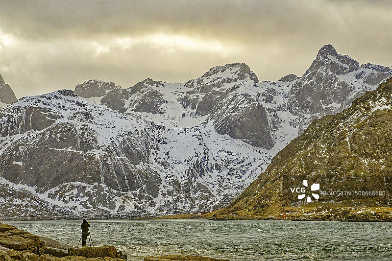 挪威罗弗敦群岛，摄影师在雪山湖边的风景图片素材