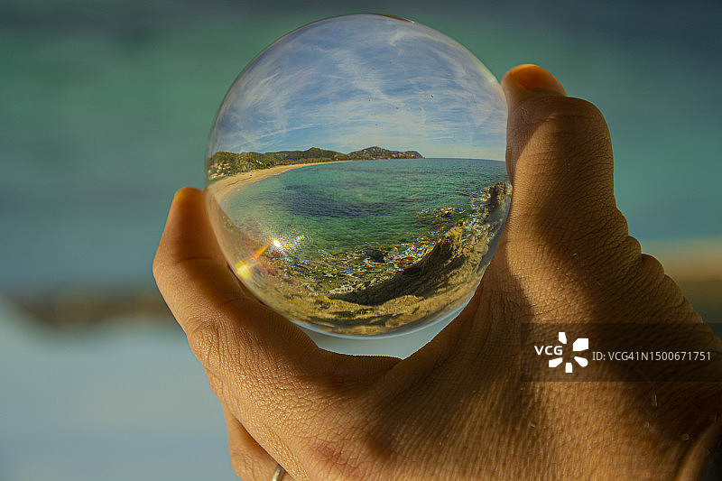 手持水晶球反射大海的局部照片，意大利图片素材