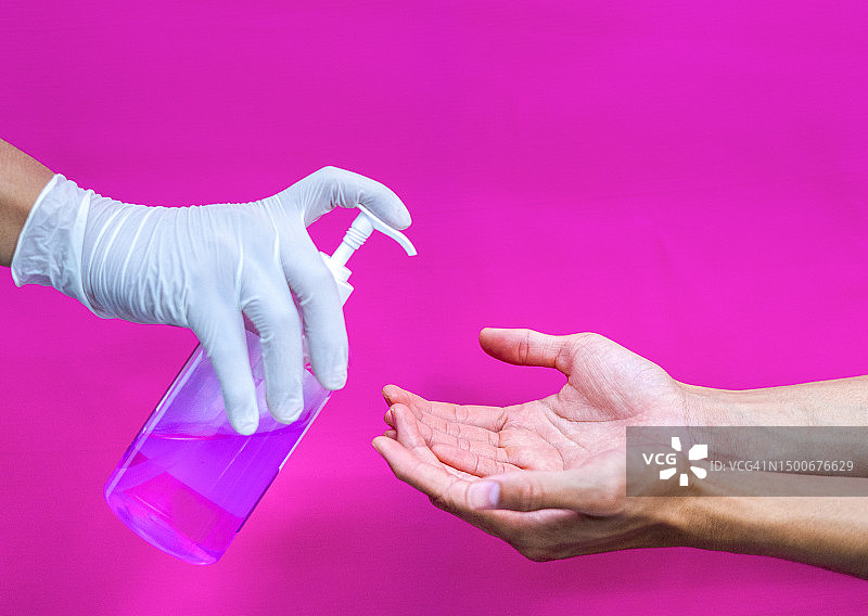 戴手套的手喷洒免洗洗手液图片素材