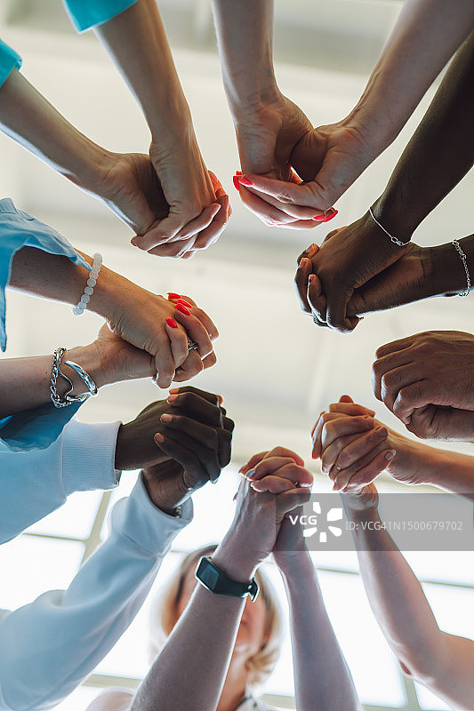治疗中多种族紧握的双手围成一圈。不同国籍的人手牵手，多样性在实现成功中的作用图片素材