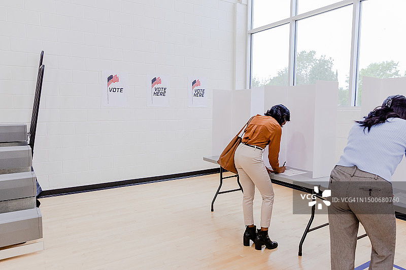两位身份不明的妇女在选票上填写选票图片素材