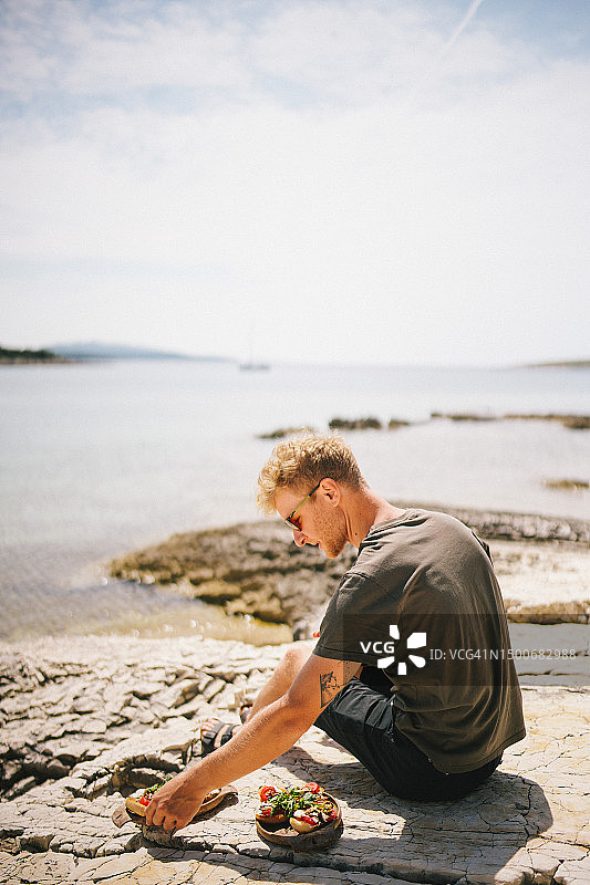 年轻男人吃新鲜三明治图片素材