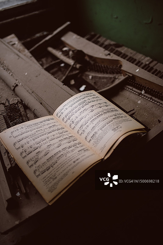 破损钢琴上的音乐笔记本图片素材