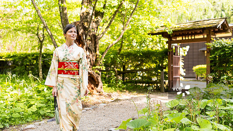 身穿和服的女性游客走在日本的林间小路上图片素材