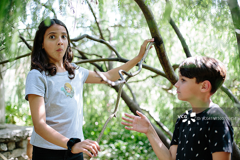 抓住树枝，看起来遇到麻烦的少女图片素材