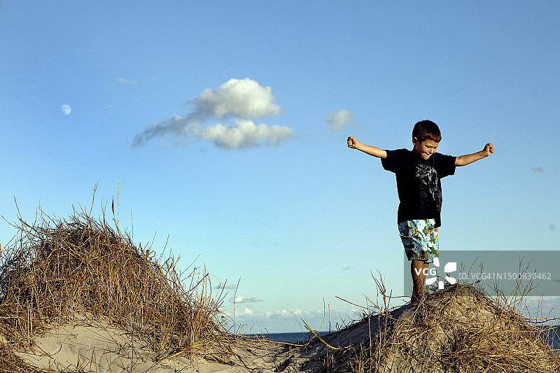 男孩在北卡罗来纳州外滩沙滩玩耍图片素材