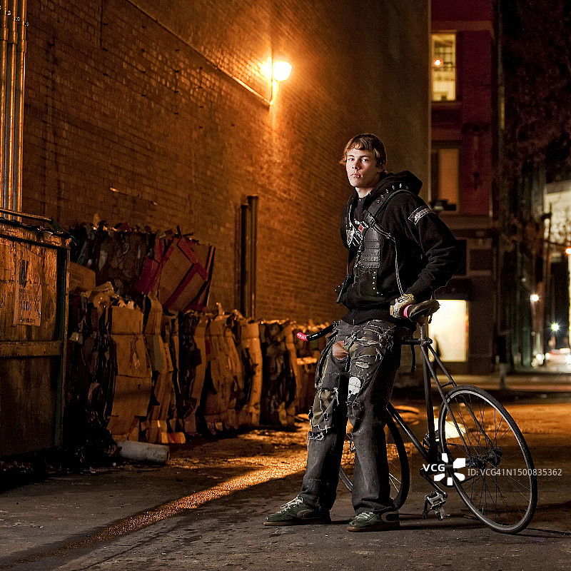 骑手在黑暗的小巷里摆姿势图片素材