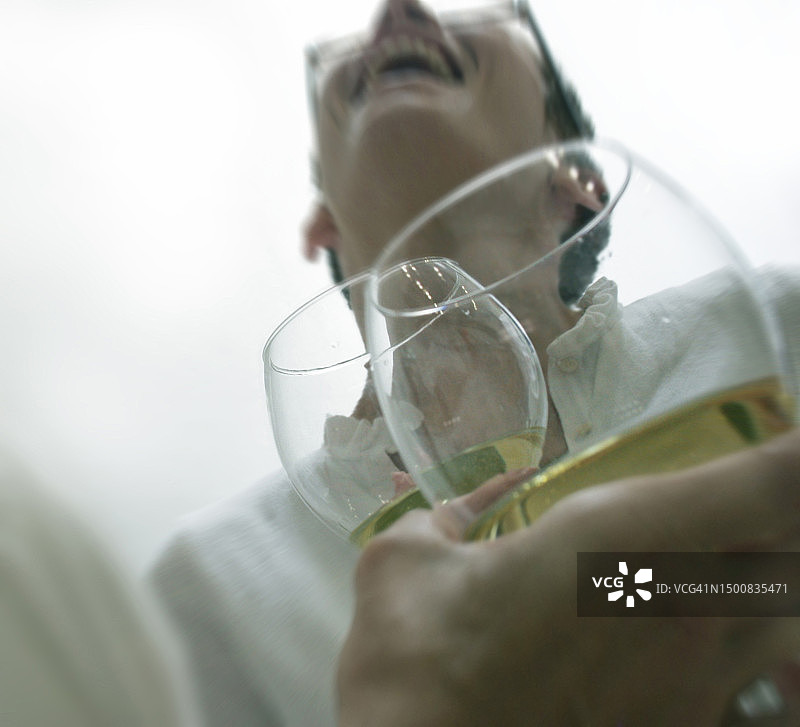 一位女士在田纳西州纳什维尔与朋友喝着葡萄酒聊天欢笑图片素材