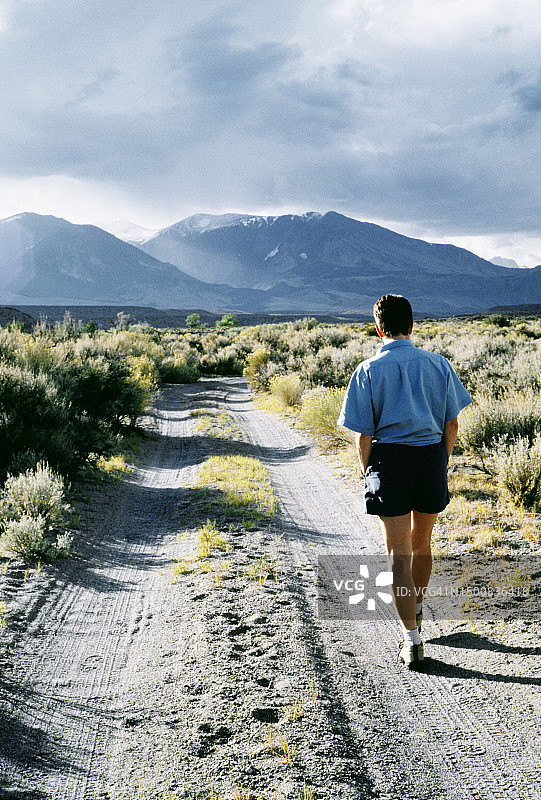 走在土路上的女子背影图片素材
