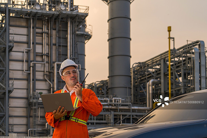 石油炼油工程师使用平板电脑和对讲机图片素材