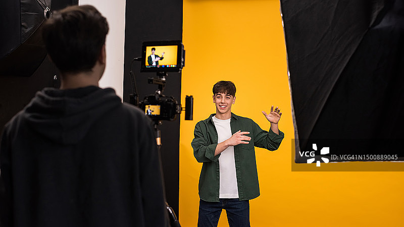 专业摄影师在橙色背景下拍摄青少年男孩，摩尔多瓦图片素材