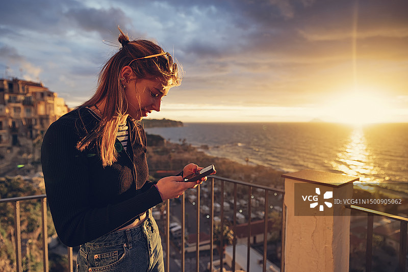 少女在特罗佩亚小镇拍摄日落图片素材