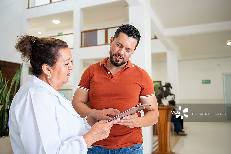 病人与医生交谈并填写医疗检查表图片素材