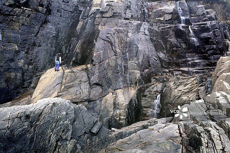 徒步者探索美国缅因州阿卡迪亚国家公园的海岸悬崖图片素材