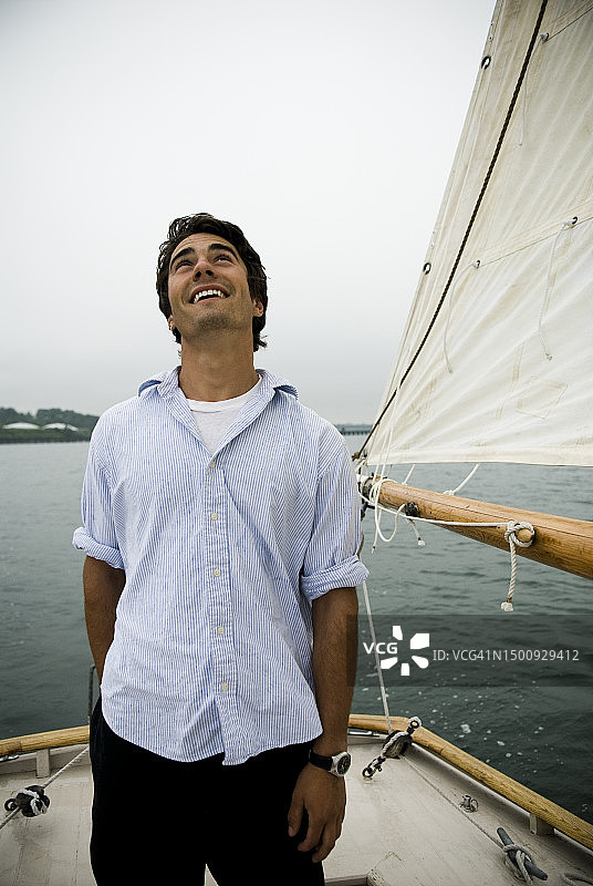 男人抬头看帆船，缅因州卡斯科湾，新英格兰图片素材