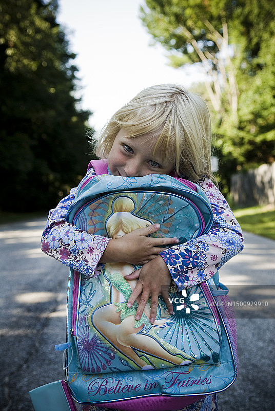 在缅因州街头背着背包等公交车的女孩图片素材