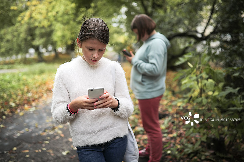 公园：沉迷于智能手机的青少年，反映了对电子产品的依赖图片素材
