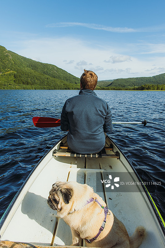 男人在挪威风景优美的湖上划独木舟图片素材