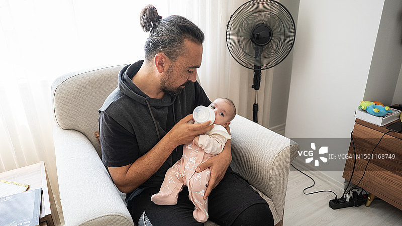 现代父亲在家给宝宝喂奶图片素材