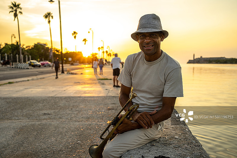 在古巴哈瓦那街头，一位中年男人拿着小号图片素材