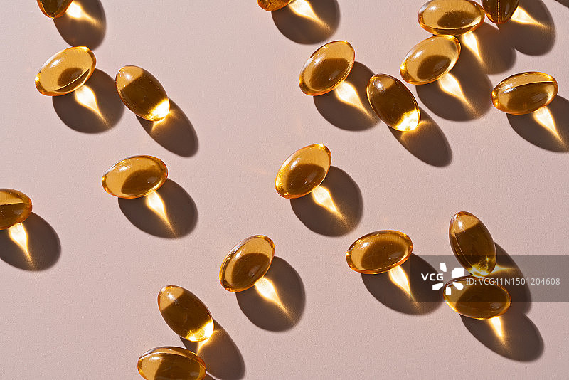 米色背景上的鱼油软胶囊图片素材