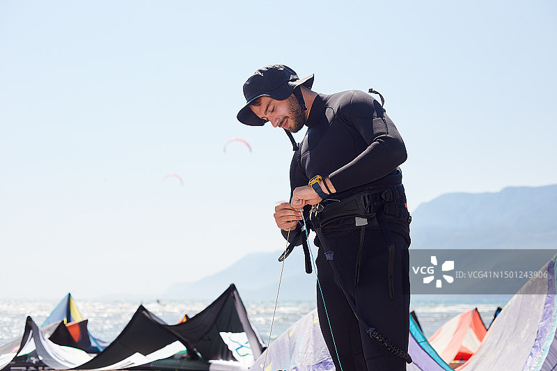年轻教练在海滩上为女子准备风筝冲浪图片素材