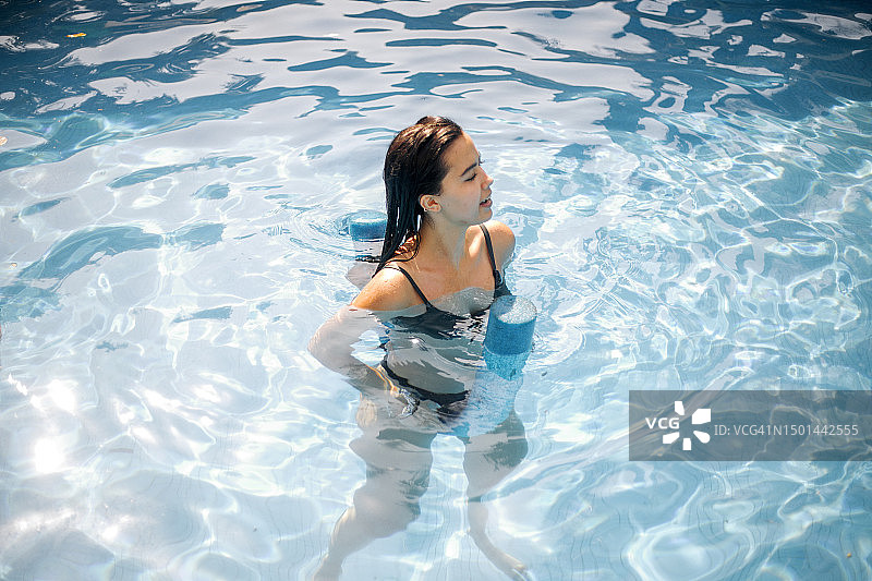 年轻女子在夏天于泳池游泳图片素材