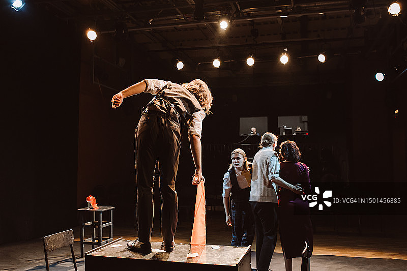 戏剧社团的四名年轻成员在舞台上表演情感剧图片素材