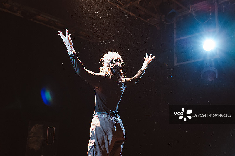 迷人的女演员在学生剧社舞台上进行情感独奏图片素材