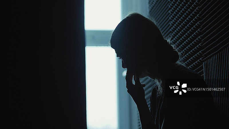 女孩坐在黑暗的房间里，遭受精神崩溃——抑郁症图片素材