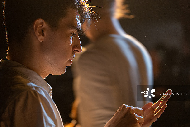 准备在业余剧院舞台上表演的英俊年轻男人的侧面图图片素材