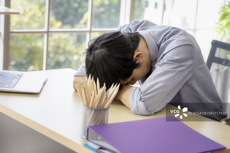 工作结束后在办公桌上感到疲倦想睡觉的军官图片素材