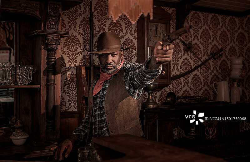 狂野西部背景下的英俊黑人牛仔图片素材