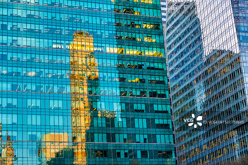 曼哈顿中城，现代玻璃办公大楼反射橙色老式摩天大楼的景象图片素材