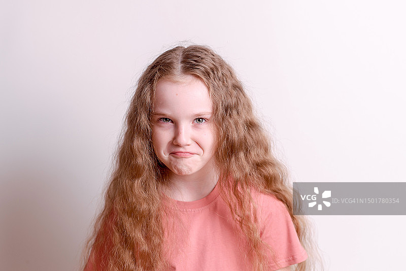 白色背景上生气嘟嘴的可爱女孩肖像图片素材