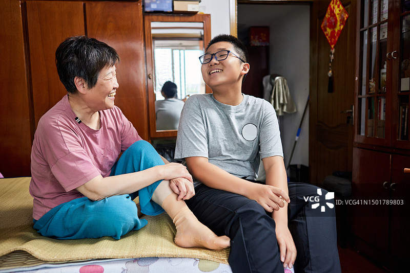 中国奶奶和孙子在卧室床上开心聊天图片素材