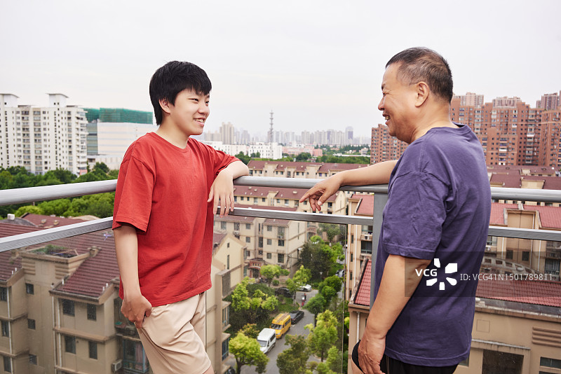 中国爷爷和孙子在阳台上聊天图片素材