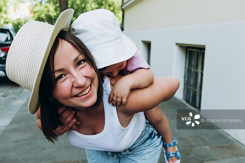 幸福家庭：妈妈背着儿子特写图片素材